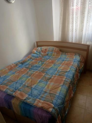 a bed with a colorful comforter in a bedroom at Daire in Kuşadası