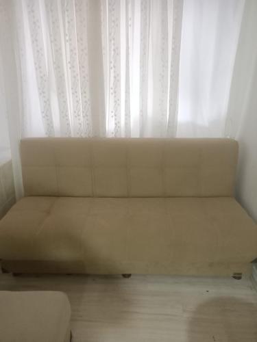 a white couch sitting in front of a window at Daire in Kuşadası