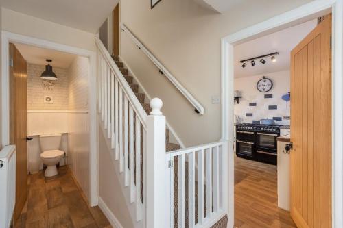 a white staircase in a home with a kitchen at Broomfield Cottage Nr Pickering - DOGS STAY FOR FREE in Pickering