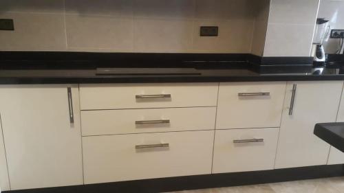 a kitchen with white cabinets and a black counter top at Résidence Repos in Casablanca