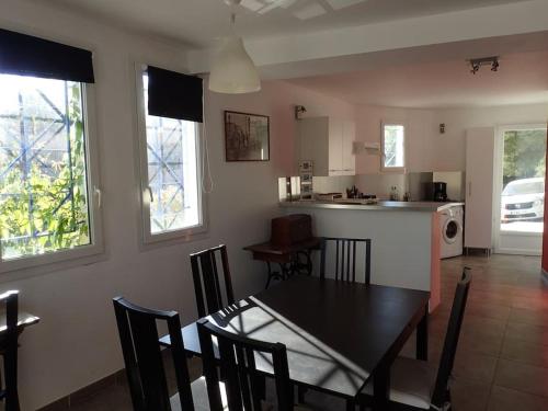 - une salle à manger et une cuisine avec une table et des chaises dans l'établissement Chez Pascal grand T2 de 55m2 indépendant dans villa, à Sausset-les-Pins