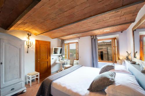 a bedroom with a large bed with a wooden ceiling at Il Casello Country House in Greve in Chianti