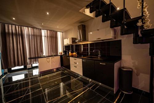 Il comprend une cuisine dotée de carrelage noir et blanc et d'un évier. dans l'établissement Le Loft Nancy, à Nancy