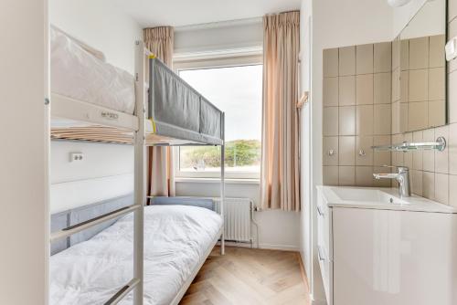 1 dormitorio con litera y lavamanos en Zeezicht Villa Strand direct bij zee, en Bergen aan Zee