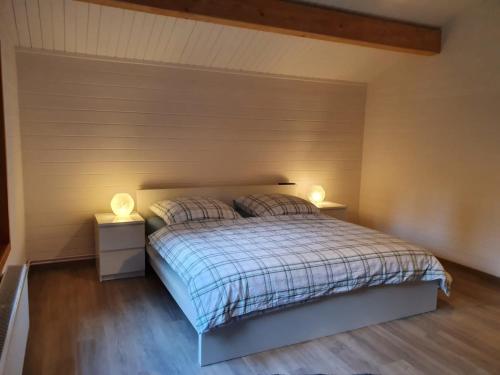 una camera da letto con un letto con due lampade sopra di Ferienhaus Seebrise - a90151 a Bad Bederkesa
