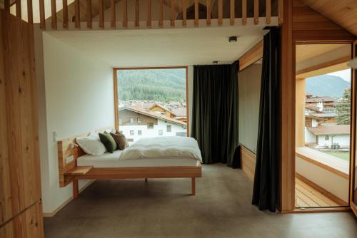 a bedroom with a bed and a large window at Haus Aerli in Ehrwald