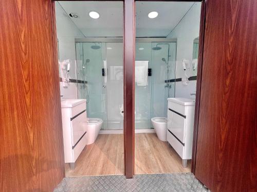 uma casa de banho com 2 WC e chuveiros em vidro em Caravana Con Encanto El Palmar 4 em El Palmar