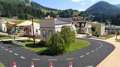 a winding road in a small town with orange traffic cones at Kamzik Apartment hill view with garage in Donovaly