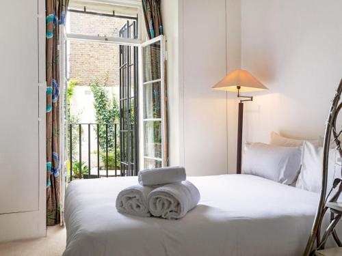 a bedroom with a bed with towels on it at Pass The Keys Perfect Blend of Comfort Charm in London