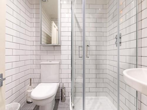 a white bathroom with a toilet and a sink at Pass The Keys Perfect Blend of Comfort Charm in London