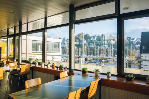 un restaurant avec des tables et des chaises et une grande fenêtre dans l'établissement Auberge de Jeunesse de Morlaix, à Morlaix