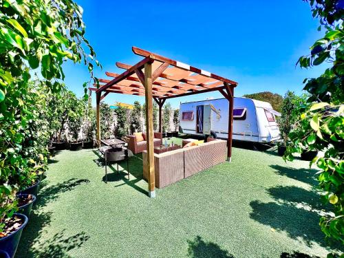 patio con divano sotto un padiglione e un camper di Caravana Con Encanto El Palmar 4 a El Palmar