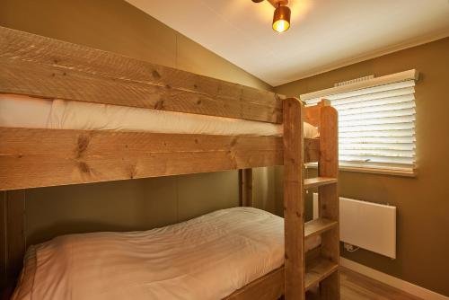 kilka łóżek piętrowych w pokoju w obiekcie Luxe hippe Lodge in de bossen van Oisterwijk w mieście Oisterwijk