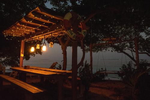 a wooden picnic table under a canopy at night at Thundi Village & Spa in Maalhos