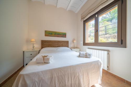 - une chambre avec un grand lit blanc et 2 serviettes dans l'établissement HomeHolidaysRentals Paz - Costa Barcelona, à Vallgorguina