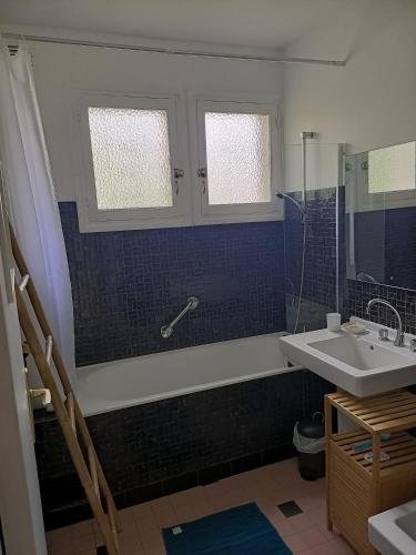 une salle de bain avec un lavabo, une baignoire et un miroir dans l'établissement Villa 100 m du Touquet entre forêt et mer, à Cucq