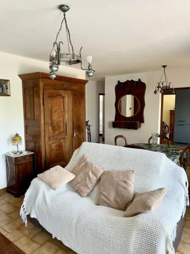 une chambre avec un lit blanc avec des oreillers et un miroir dans l'établissement Les oliviers du pradon, à Lagarde-Paréol