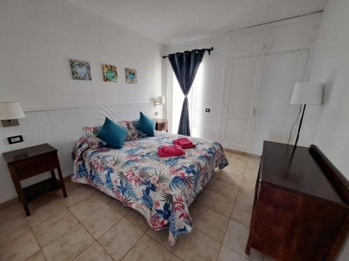 a bedroom with a bed with blue pillows and a window at Jesnery Home in Puerto del Carmen
