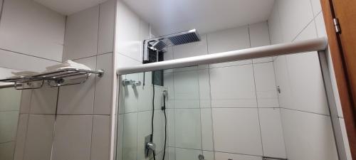a bathroom with a shower with a glass door at ILOA Residence Flat Alagoas in Barra de São Miguel