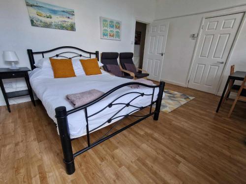 um quarto com uma cama preta e branca com almofadas laranja em Studio Apartment, Private Parking, Walk To Centre, Uni and Hospital, Long Stay Prices em Exeter