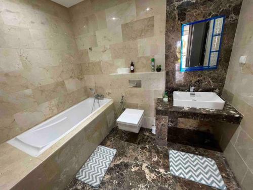 een badkamer met een bad, een wastafel en een toilet bij Apparemment luxueux Ritz Carlton in Sania Torres
