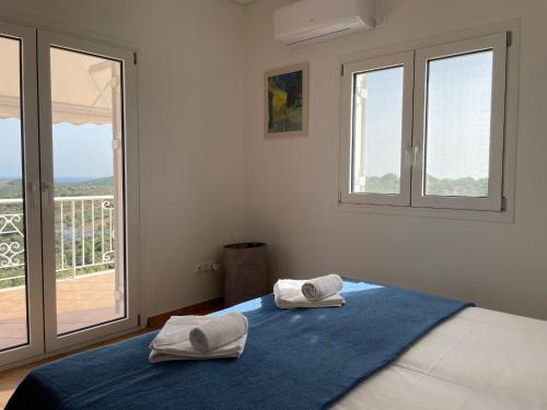 een slaapkamer met 2 handdoeken op een bed en een balkon bij Villa Valleyview Methoni in Methoni