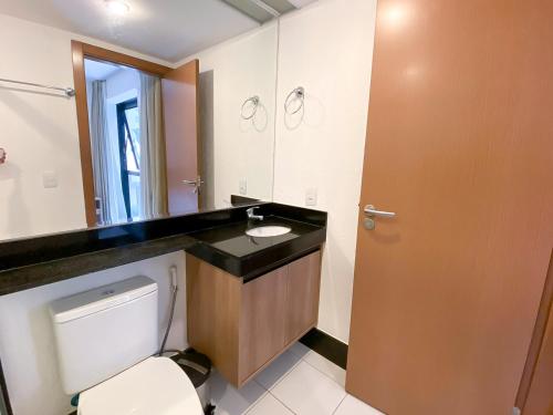 a bathroom with a sink and a toilet and a mirror at Acomodação Particular no Edifício Athos Bulcão - NÃO É INCLUSO CAFÉ - 3º andar in Brasilia