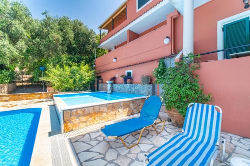 a patio with a table and chairs next to a house at Arianna Deluxe Studio 21 in Paleokastritsa