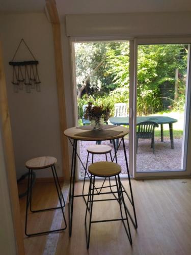 a table and two stools in a room with a patio at Pivert in Pléneuf-Val-André