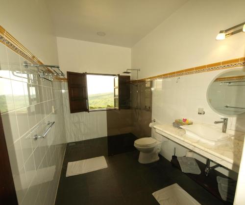 a bathroom with a sink and a toilet and a mirror at Hacienda Las Vainillas Boutique Hotel in Mastatal