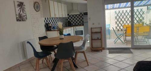 une cuisine et une salle à manger avec une table et des chaises dans l'établissement Maison de vacances en plein cœur de Châtelaillon-Plage, à Châtelaillon-Plage