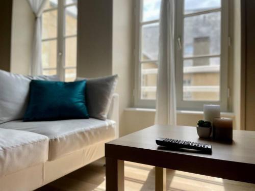 un salon avec un canapé et une table basse dans l'établissement Le Liberty by Melrose, à Bayeux