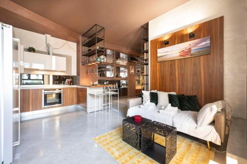 a living room with a white couch and a kitchen at Suite 46 attico con Vista cielo Milano in Milan