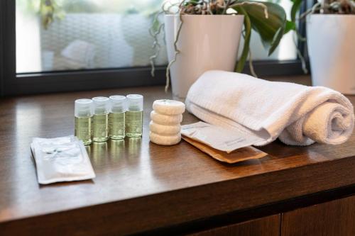 a wooden table with a towel and bottles of essential oils at Suite 46 attico con Vista cielo Milano in Milan