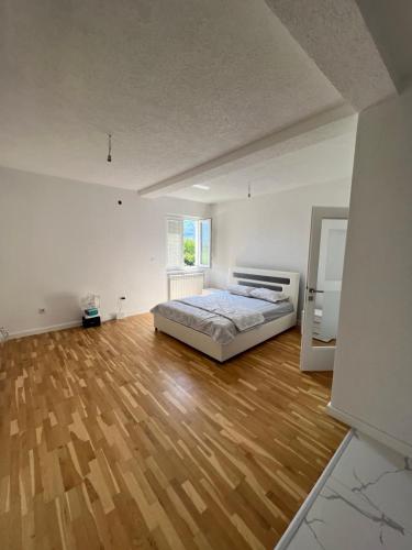 a bedroom with a bed and a wooden floor at Duča Apartmani in Plav