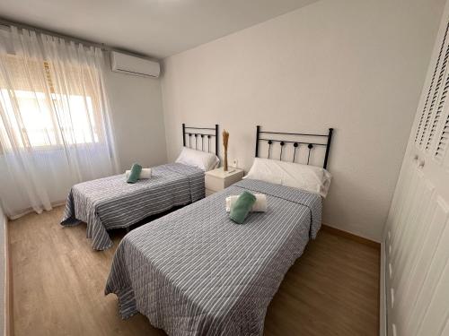 Pokój z 2 łóżkami z zielonymi poduszkami w obiekcie Fabuloso Apartamento en Rincón de la Victoria, frente a la playa w mieście Rincón de la Victoria