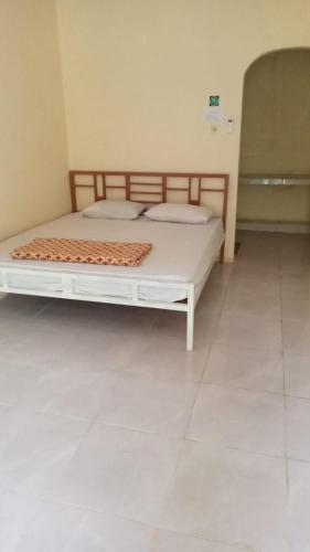 ein Schlafzimmer mit einem weißen Bett in einem Zimmer in der Unterkunft Gabe Homestay in Halangan