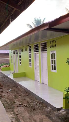 una pequeña casa verde con puertas blancas. en Gabe Homestay, en Halangan