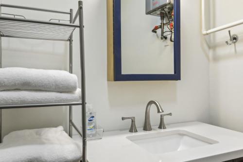 a bathroom with a sink and a mirror and towels at Modern Cambridge Cottage Walk to Town, Waterfront in Cambridge
