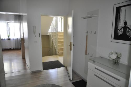 um quarto com um corredor com paredes brancas e uma porta em Kurstadt Apartment 2ZKB Balkon PKW Stlp-Self-Check-in em Bad Nauheim
