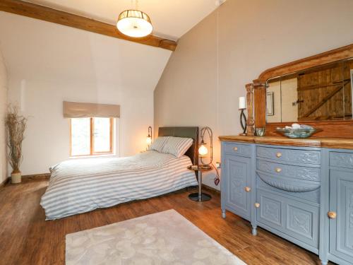 um quarto com uma cama e uma cómoda azul em Wheatlow Brooks Barn em Stafford