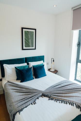 a bedroom with a large bed with blue pillows at Access Brick Lane in London