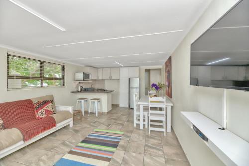 a living room with a couch and a kitchen at Land's Edge Eco Friendly Cottages and Apartments in Struisbaai