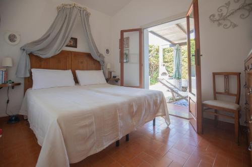 a bedroom with a bed and a sliding glass door at Villetta Schiopparello by HelloElba in Portoferraio