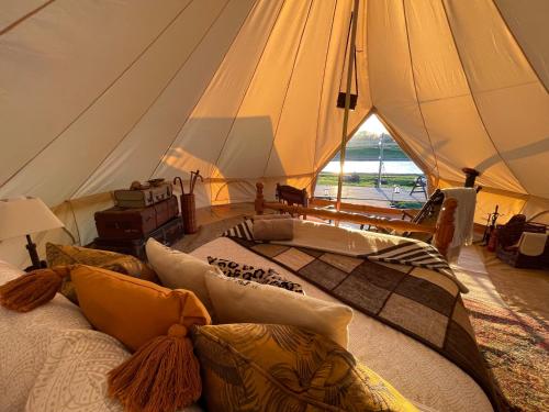 Una habitación con una cama grande en una tienda de campaña en Bain View Glamping, en Horncastle