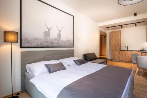 a bedroom with a bed and a picture of two deer at TALBERG SK - Garage parking - Quiet place - Brand new apartments - Tále in Tale