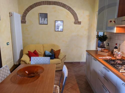a kitchen with a couch and a table in a room at Il poggio più 'n giù in Volterra