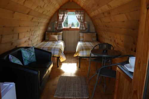 a room with two beds and a couch in a cabin at Knapp Farm Glamping Puki Pod in Corscombe
