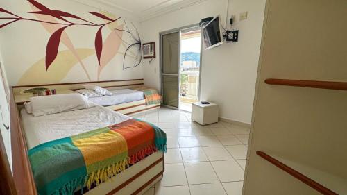 a bedroom with two beds and a painting on the wall at Cobertura Guarujá in Guarujá