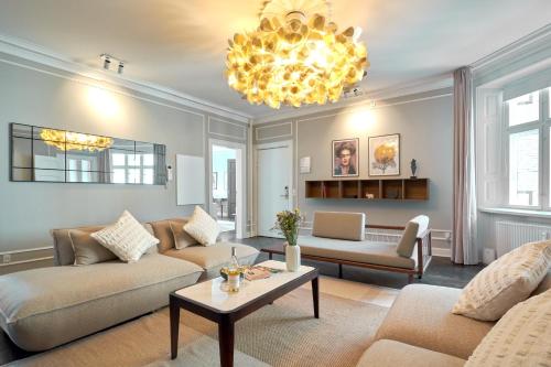 a living room with two couches and a chandelier at Large 4 bedroom with Balcony & Bathtub in CPH City in Copenhagen